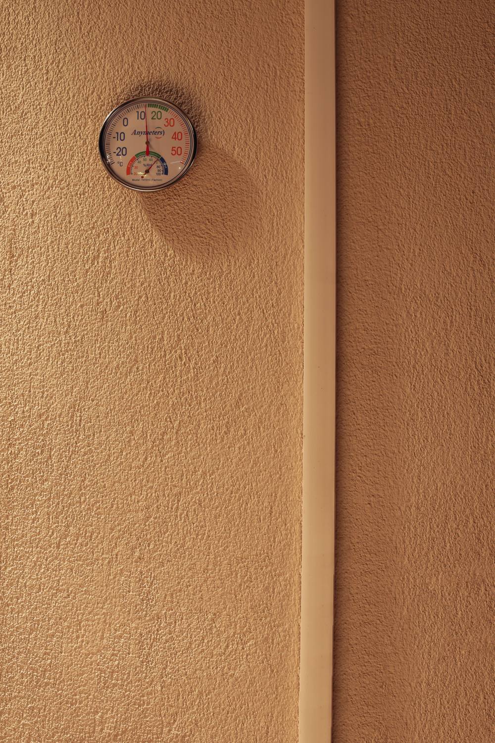 Analogue temperature and humidity gauge mounted on a wall